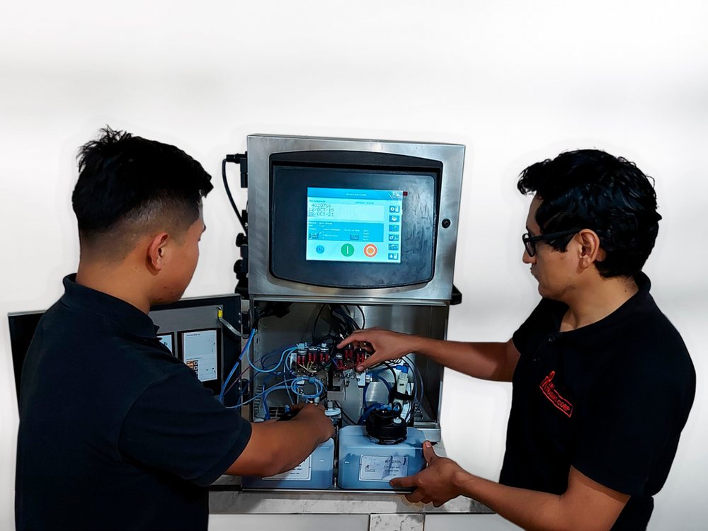 Técnicos de ART TRADING CORP realizando mantenimiento a un equipo codificador