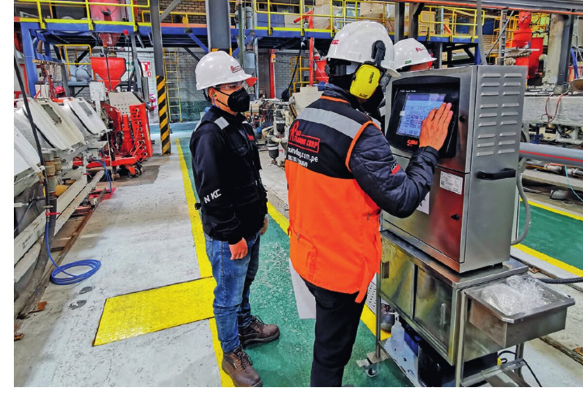 Técnico de ART TRADING CORP calibrando codificador industrial en planta de producción